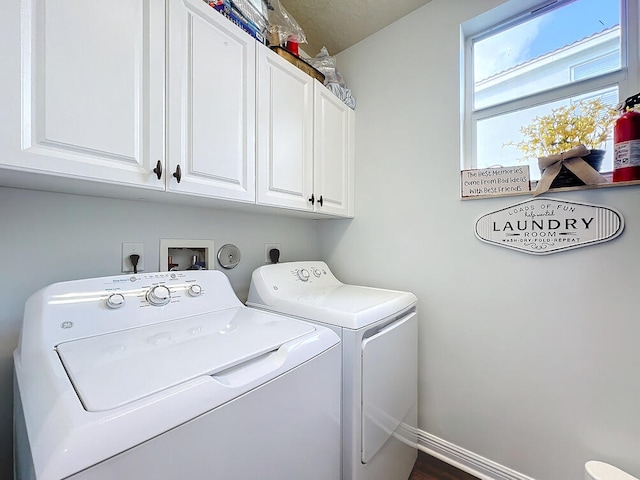 clothes washing area with cabinets and washing machine and clothes dryer