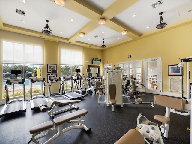 workout area featuring a high ceiling and coffered ceiling