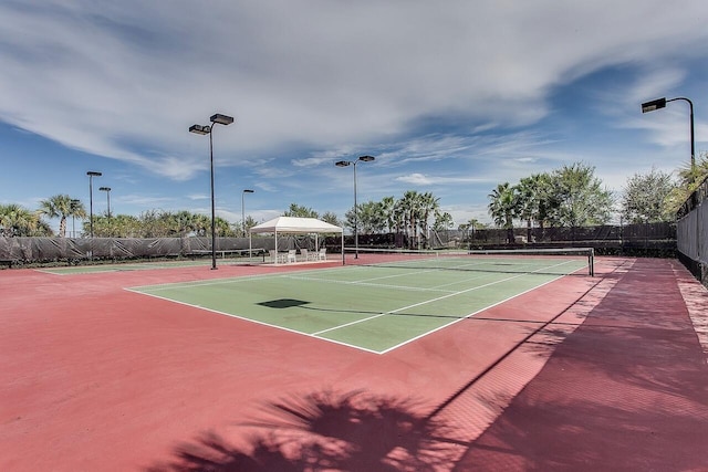 view of tennis court with a gazebo and basketball hoop