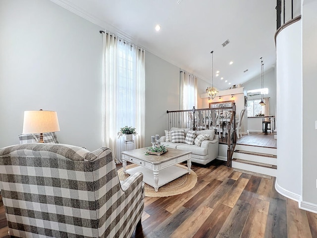 living room featuring dark hardwood / wood-style floors, crown molding, and a chandelier