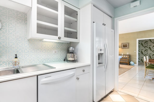 kitchen with white cabinetry, white appliances, light tile patterned floors, and tasteful backsplash