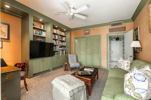 living room featuring built in features, light colored carpet, ceiling fan, and ornamental molding