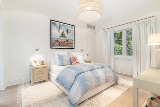 bedroom featuring ornamental molding and wood-type flooring