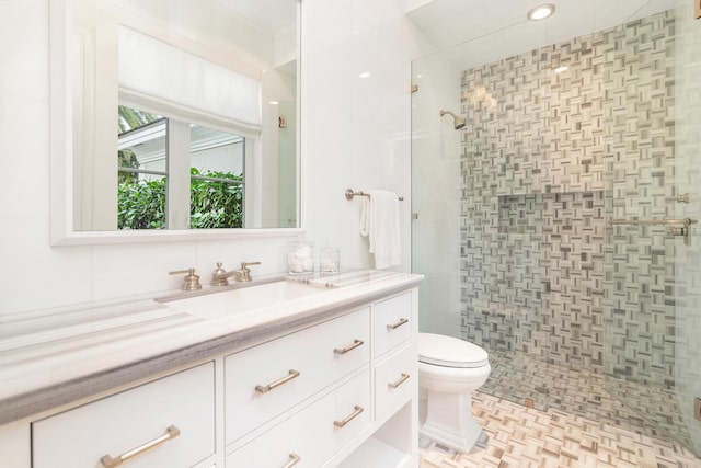 bathroom featuring tile walls, toilet, a shower with door, and vanity