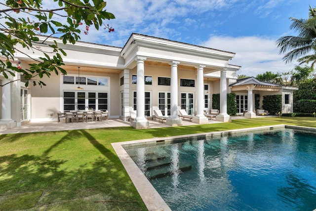 back of property with french doors, a yard, and a patio