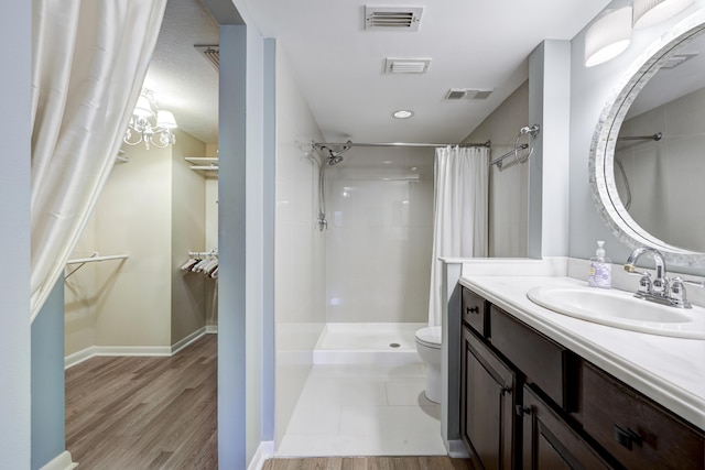 bathroom with hardwood / wood-style floors, toilet, vanity, and a shower with curtain