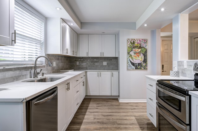 kitchen with a wealth of natural light, appliances with stainless steel finishes, white cabinets, and sink