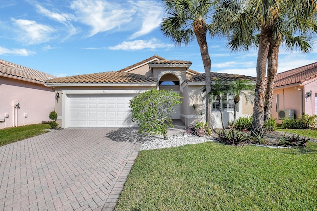 mediterranean / spanish home featuring a garage and a front yard