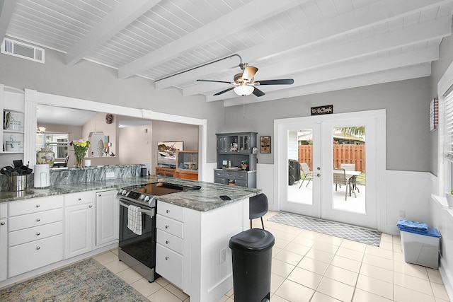 kitchen with stainless steel electric range oven, beamed ceiling, white cabinets, kitchen peninsula, and french doors