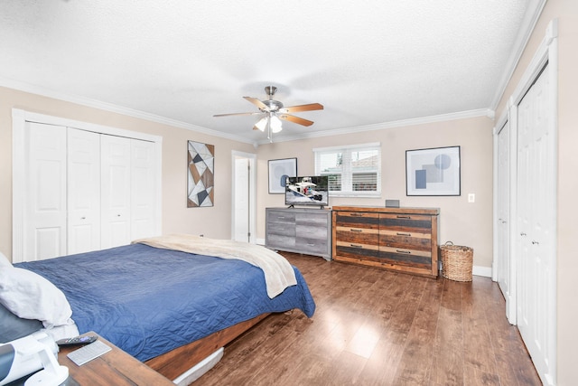 bedroom with two closets, ornamental molding, and ceiling fan