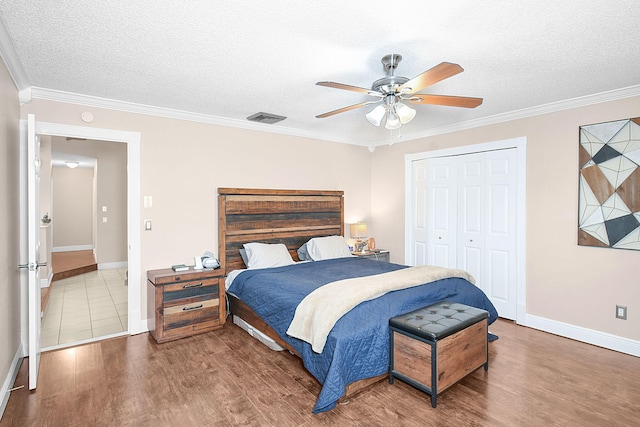 bedroom with crown molding, a textured ceiling, a closet, and ceiling fan