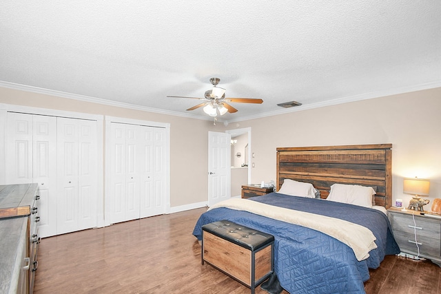 bedroom featuring ceiling fan, ornamental molding, dark hardwood / wood-style floors, and a textured ceiling