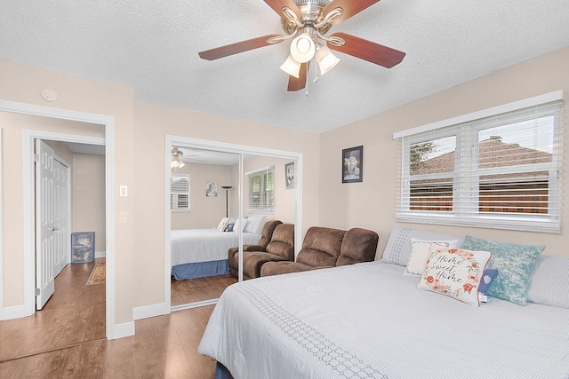 bedroom with multiple windows, a textured ceiling, ceiling fan, and a closet