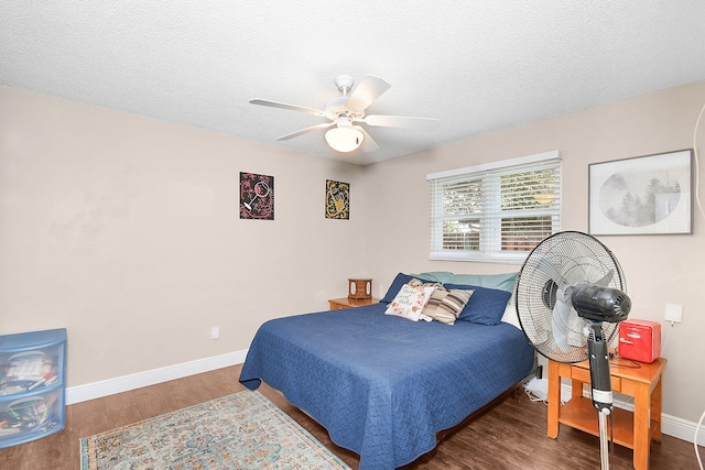 bedroom with dark hardwood / wood-style floors, a textured ceiling, and ceiling fan