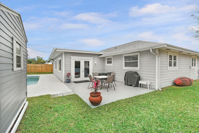 back of house featuring fence, french doors, a patio area, and a yard