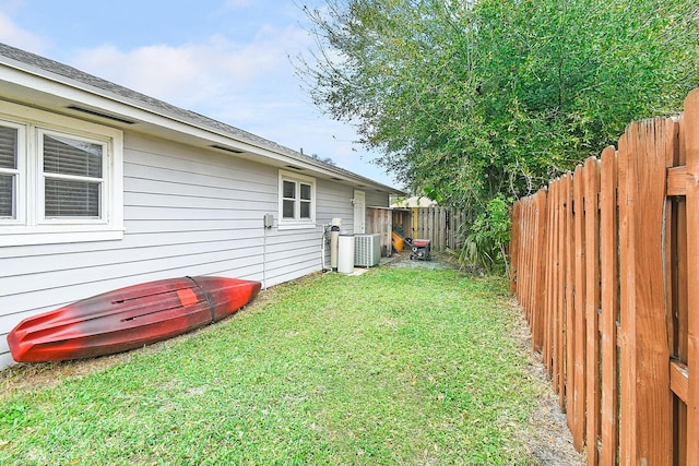 view of yard with central AC unit and a fenced backyard