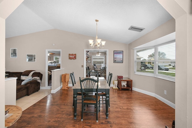 dining space with wood finished floors, visible vents, and vaulted ceiling