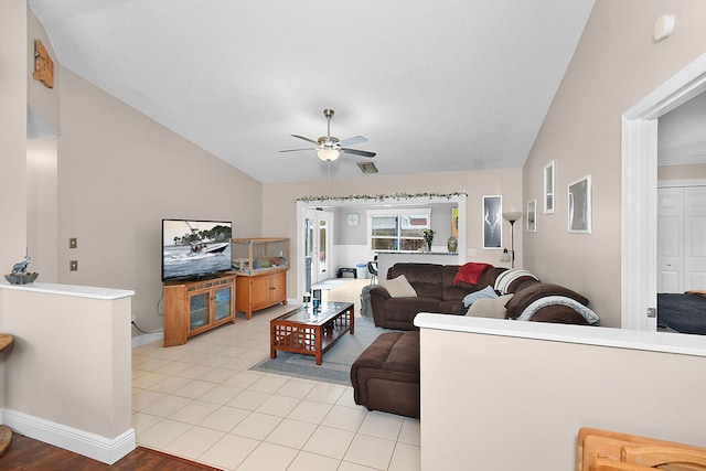 tiled living room featuring ceiling fan and lofted ceiling