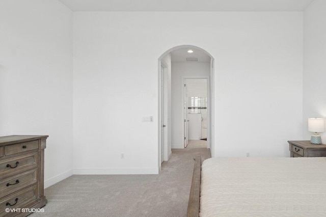 bedroom with light colored carpet and ensuite bathroom