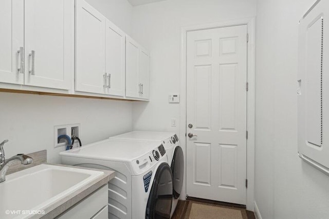 washroom with cabinets, sink, and washing machine and clothes dryer