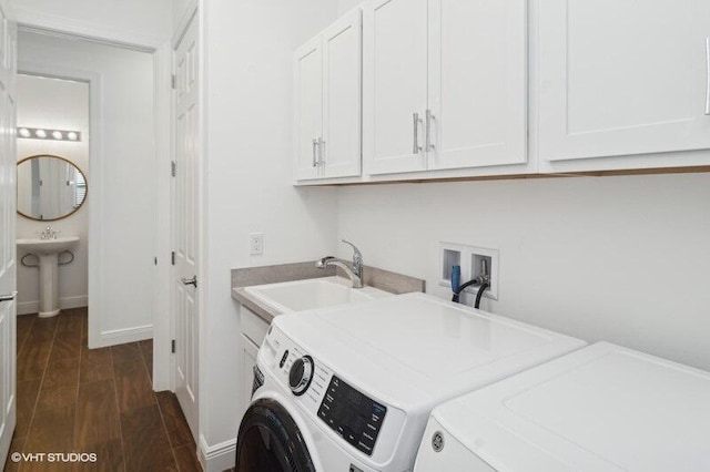 washroom with sink, washing machine and clothes dryer, and cabinets