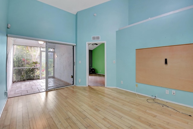 interior space featuring a towering ceiling and wood-type flooring