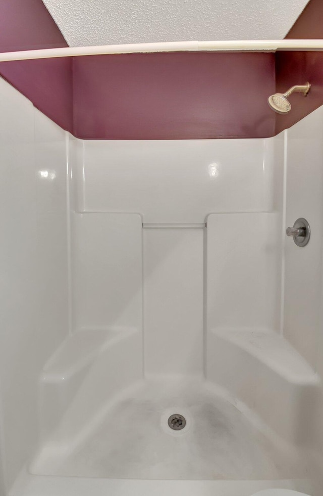 bathroom featuring a textured ceiling and walk in shower