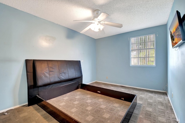 unfurnished bedroom with a textured ceiling, ceiling fan, and carpet flooring