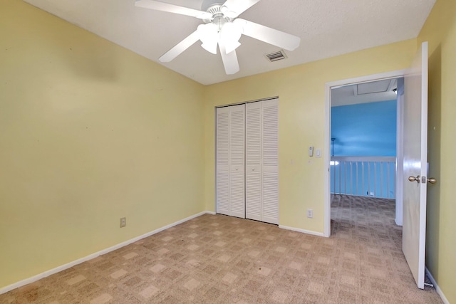 unfurnished bedroom with light carpet, ceiling fan, and a closet