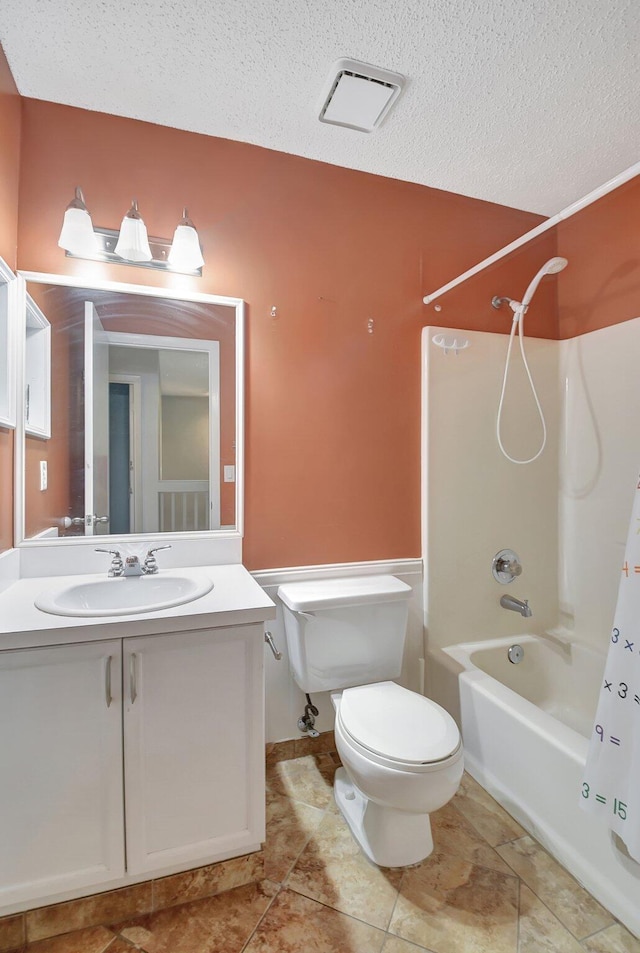 full bathroom with a textured ceiling, toilet, vanity, and shower / bath combination with curtain