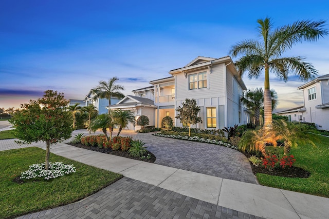 view of front of property with a balcony and a yard