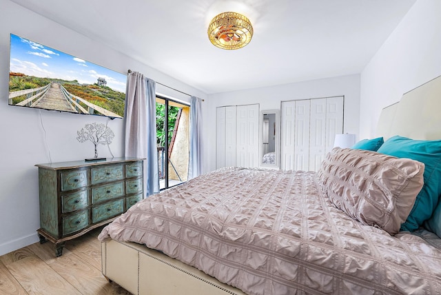 bedroom featuring light hardwood / wood-style floors, access to outside, and multiple closets