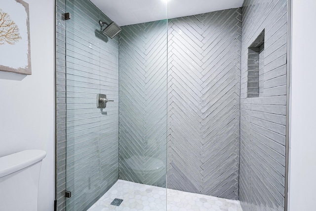 bathroom featuring toilet and tiled shower