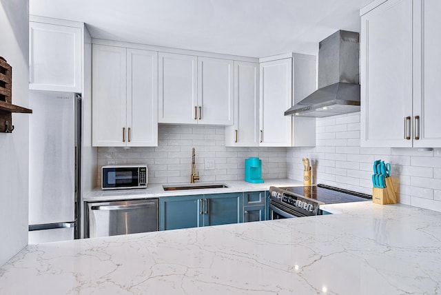 kitchen with stainless steel appliances, sink, white cabinets, and wall chimney range hood