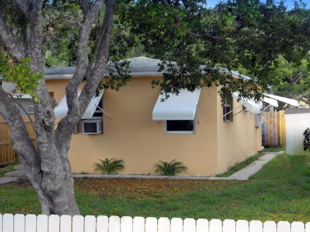 view of side of property with cooling unit and a yard