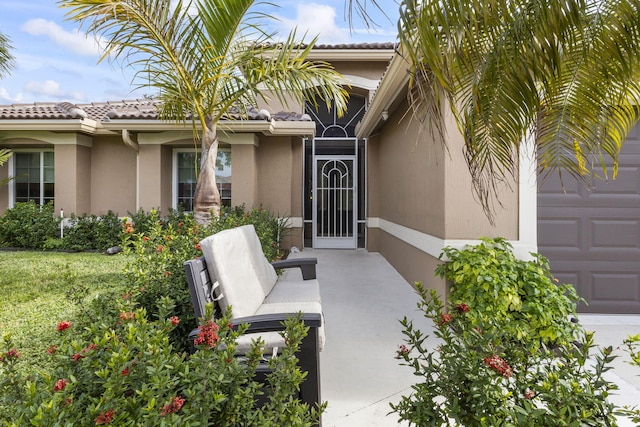 entrance to property featuring a garage and a yard