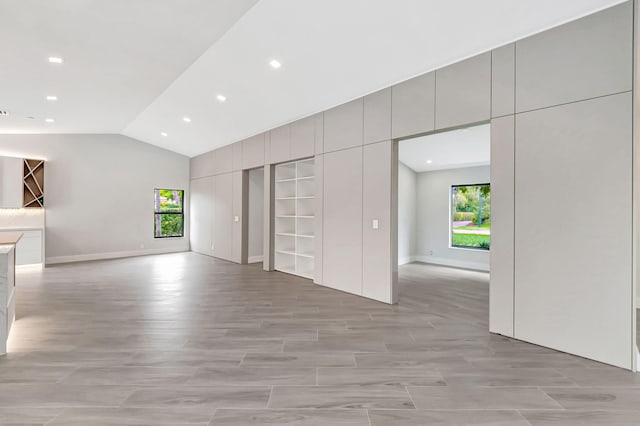 unfurnished living room with lofted ceiling and plenty of natural light