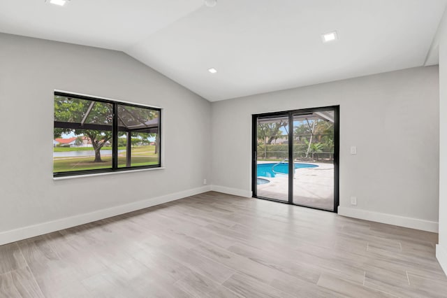 unfurnished room with lofted ceiling and light hardwood / wood-style floors