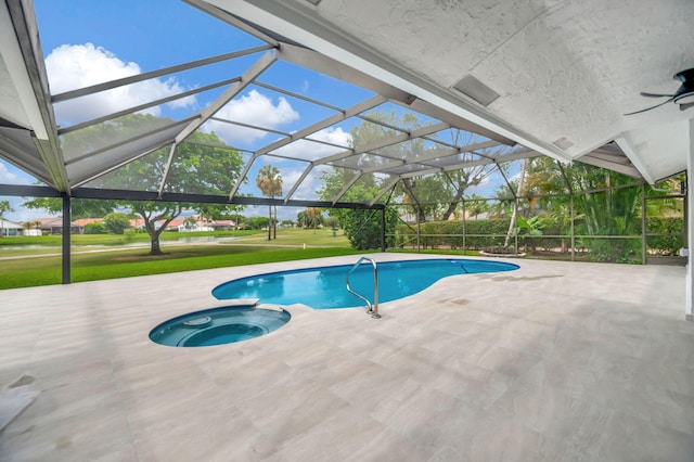 view of pool with an in ground hot tub, a lanai, a lawn, and a patio