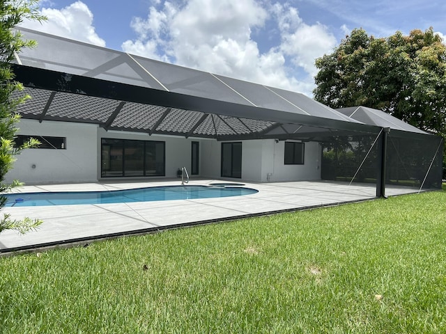 view of pool featuring a yard, a patio area, and glass enclosure