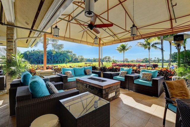 view of patio / terrace featuring ceiling fan, a gazebo, and an outdoor living space with a fire pit