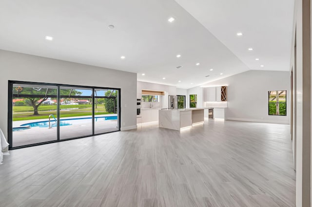 unfurnished living room with lofted ceiling and light hardwood / wood-style floors