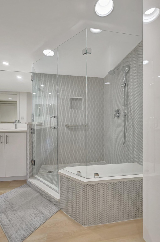 bathroom featuring vanity, hardwood / wood-style floors, and a shower with shower door