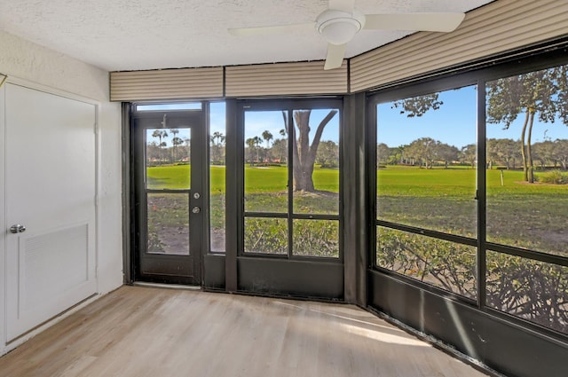 unfurnished sunroom with ceiling fan