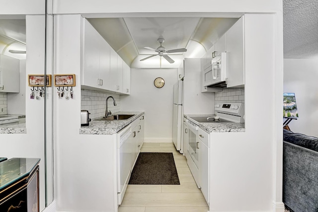 kitchen with ceiling fan, decorative backsplash, sink, white appliances, and white cabinets