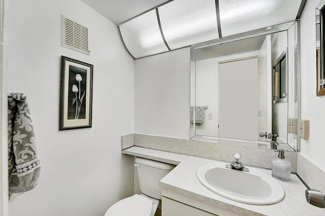 bathroom with toilet and vanity