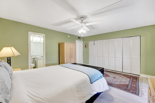 bedroom featuring a textured ceiling, ceiling fan, light hardwood / wood-style floors, and connected bathroom