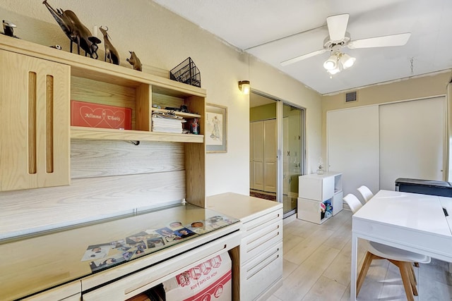 kitchen featuring light wood-type flooring, ceiling fan, and light brown cabinets