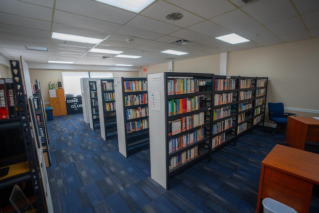 office with a paneled ceiling and dark carpet