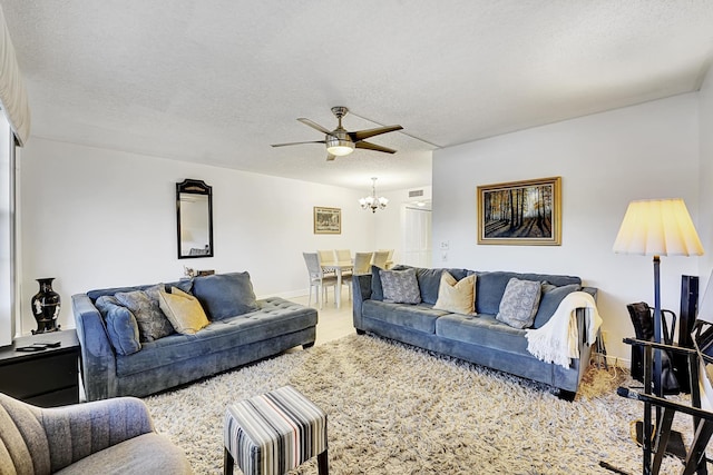 living room with ceiling fan with notable chandelier and a textured ceiling